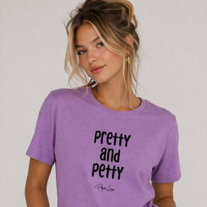 Woman wearing a purple t-shirt with 'Pretty and Petty' text on a plain background