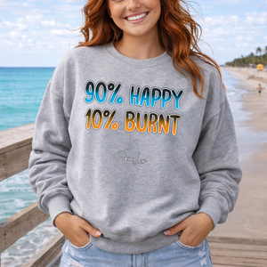 Woman wearing a gray sweatshirt with text on a beach